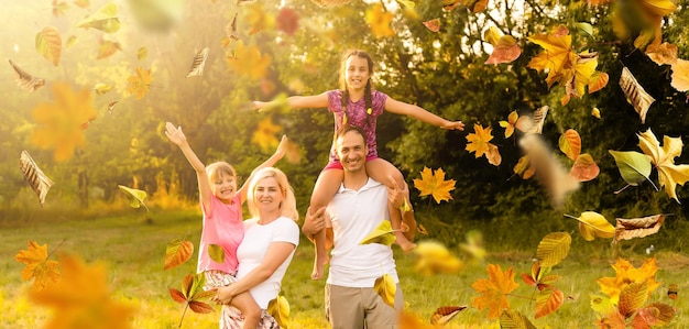 Zdjęcie uroczej rodziny w jesiennym parku, młodzi rodzice z uroczymi, uroczymi dziećmi bawiącymi się na świeżym powietrzu, pięć wesołych osób bawi się jesienią na podwórku, szczęśliwa rodzina cieszy się jesienną przyrodą.