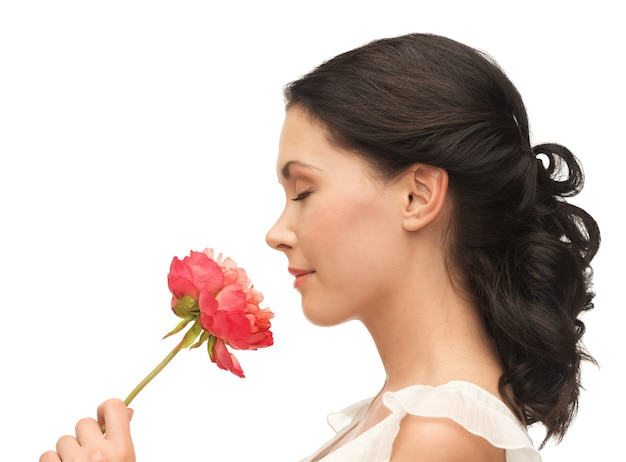 zdjęcie uśmiechniętej kobiety pachnącej kwiatem