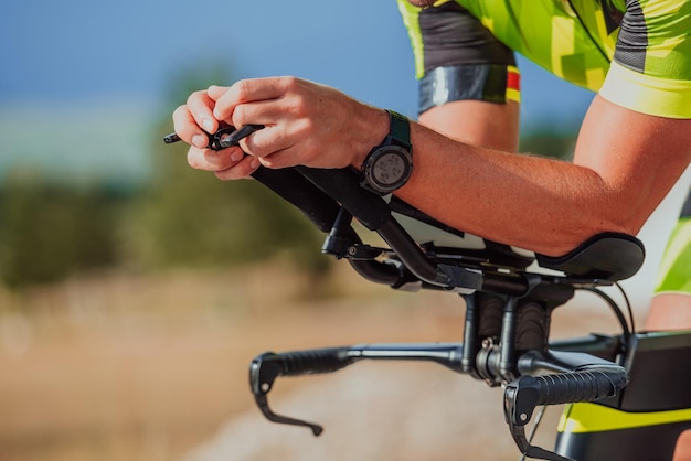 Zdjęcie z bliska aktywnego triatlonisty na rowerze w odzieży sportowej i kasku ochronnym. Selektywna ostrość.