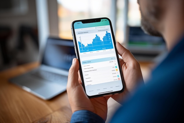 Zdjęcie z bliska biznesmena sprawdzającego wykresy giełdy na swoim urządzeniu mobilnym