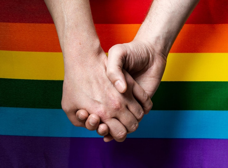Zdjęcie zdjęcie z bliska rąk z flagą lgbt w tle