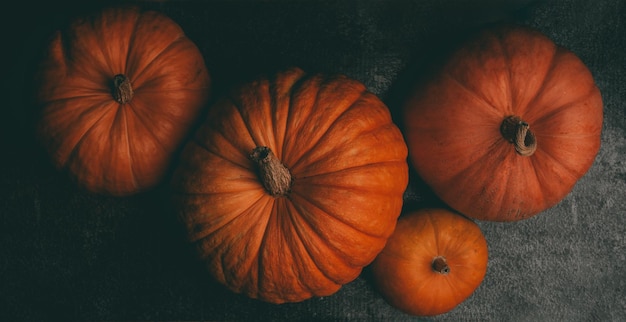 Zdjęcie z góry czterech pomarańczowych dyń na czarnym tle święto halloween