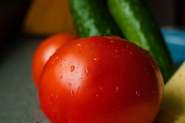 Zdjęcie z umytym czerwonym pomidorem leży na stole z kroplami wody water