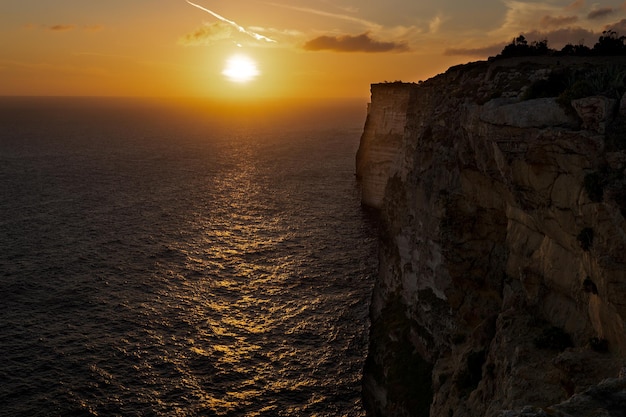 Zdjęcie zachodu słońca nad morzem z klifów