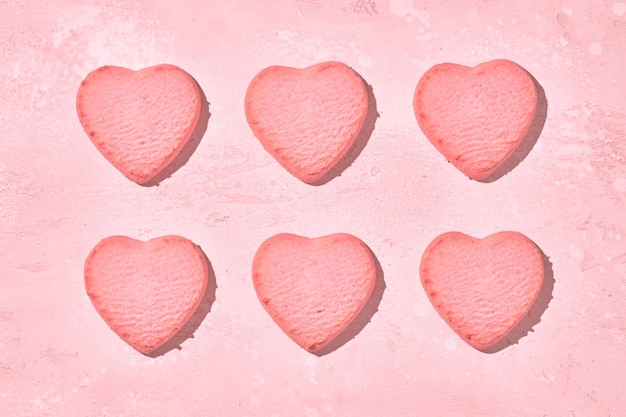 Zdobione ciasteczka w kształcie serca na różowym tle