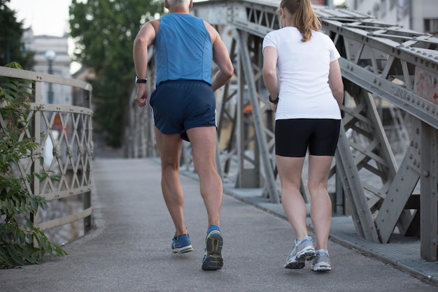 zdrowa dojrzała para jogging w mieście wczesnym rankiem ze wschodem słońca w tle