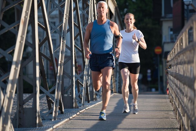 zdrowa dojrzała para jogging w mieście wczesnym rankiem ze wschodem słońca w tle