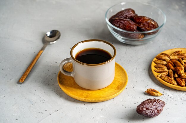 Zdrowa kawa z nasion daktyli w małych filiżankach daktyli owoce i nasiona na szarym betonowym tle łyżeczka do herbaty