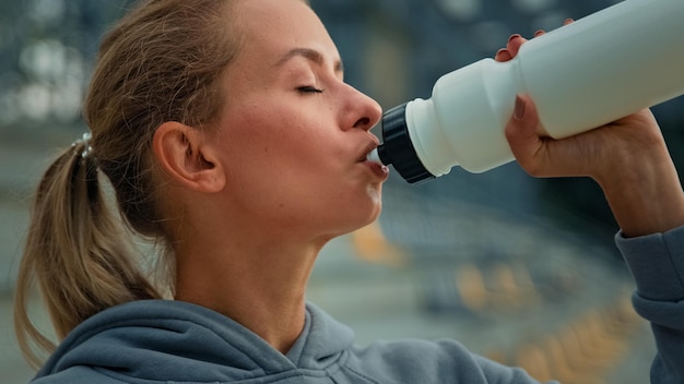 Zdrowa kobieta lekkoatletyka sportsmenka kaukaska dziewczyna biegacz jogger lekkoatletka kobieta pić świeżą wodę