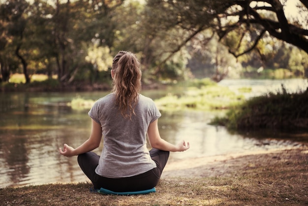 zdrowa kobieta relaksująca się podczas medytacji i ćwiczeń jogi w pięknej przyrody na brzegu rzeki