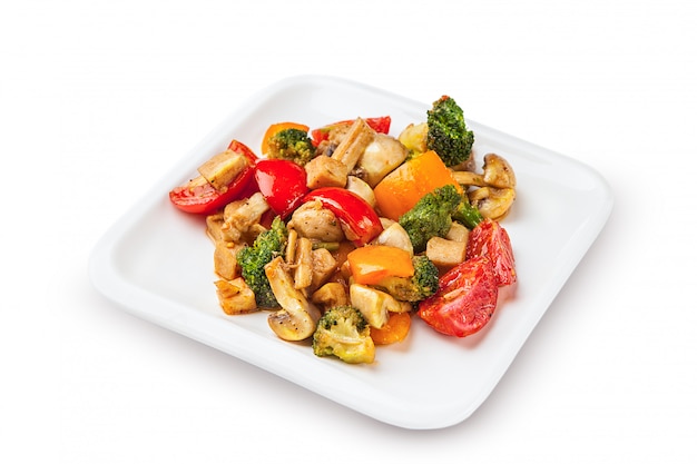 Zdjęcie zdrowa kuchnia wegetariańska z sałatką tofu z kolorowymi pieczonymi warzywami, w tym słodką papryką, cebulą i grzybami, groszkiem i brokułami.