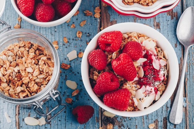 Zdrowa Miska śniadaniowa Granola Z Jogurtem Greckim, świeżymi Malinami I Nasionami Chia Na Drewnianym Tle