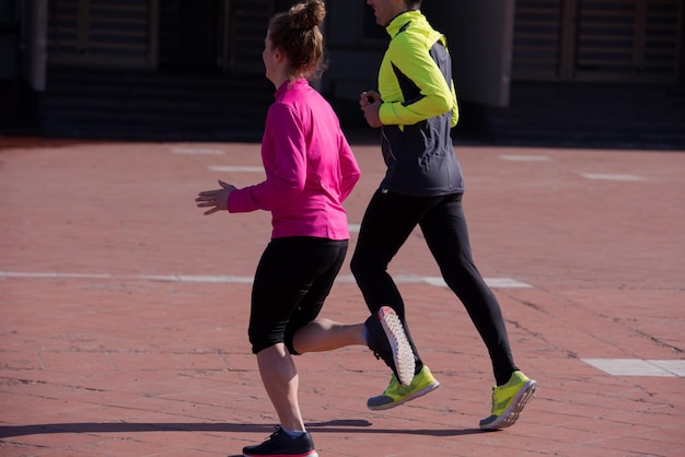 zdrowa młoda para jogging w mieście wczesnym rankiem ze wschodem słońca w tle