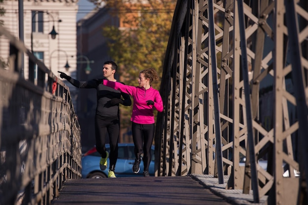 zdrowa młoda para jogging w mieście wczesnym rankiem ze wschodem słońca w tle