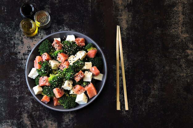 Zdrowa sałatka dla diety ketonowej. Sałatka z brokułami, białym serem i łososiem. Pomysł na lunch keto. Notatka z napisem Keto Diet.