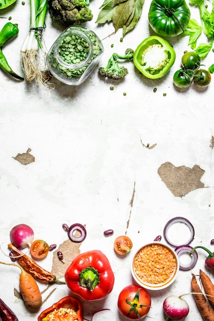 Zdrowa żywność Surowe warzywa pokrojone w plasterki z soczewicą i zielonym groszkiem na rustykalnym tle