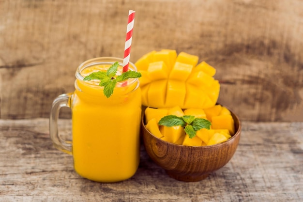 Zdrowe dojrzałe żółte mango smoothie owoce mango i kostki mango na drewnianym stole zdrowej koncepcji