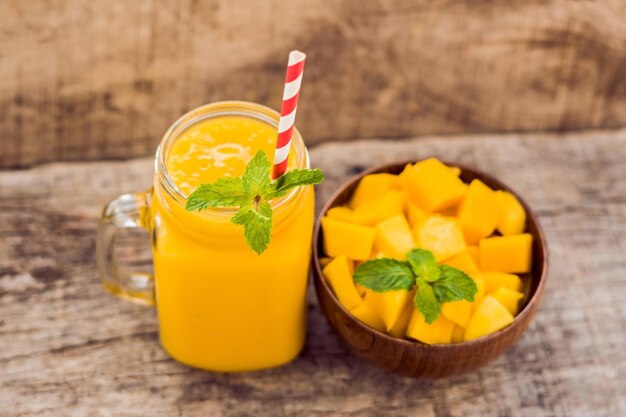 Zdrowe dojrzałe żółte mango smoothie owoce mango i kostki mango na drewnianym stole zdrowej koncepcji