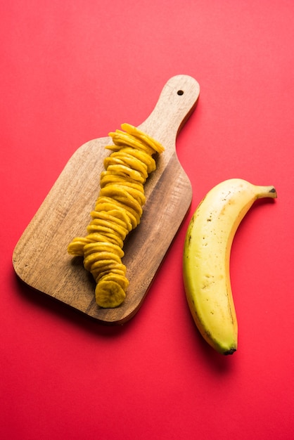 Zdjęcie zdrowe domowe chipsy lub wafle z kela lub banana podawane na nastrojowej powierzchni, selektywne skupienie