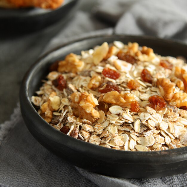 Zdrowe domowe zboża granola z orzechami i rodzynkami na szarym tle