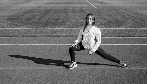 Zdrowe dziecko dziewczynka trenuje fitness na stadionie bieżnia sport sukces