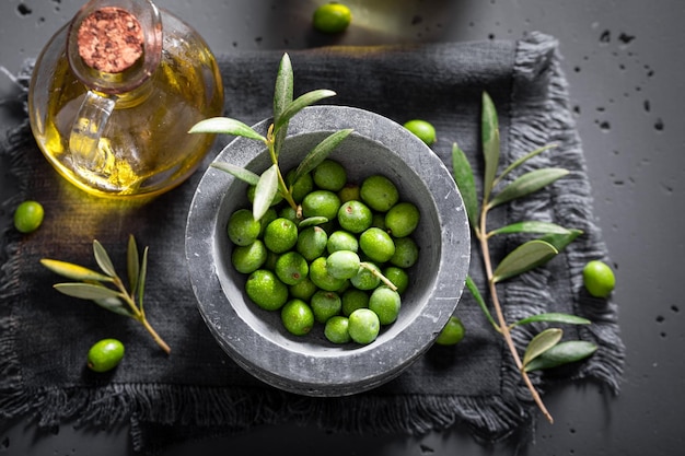 Zdjęcie zdrowe i świeże surowe oliwki z jagodami oliwnymi na gałęzi