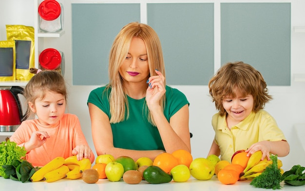 Zdrowe jedzenie w domu szczęśliwa rodzina w kuchni mama i dzieci przygotowują warzywa i