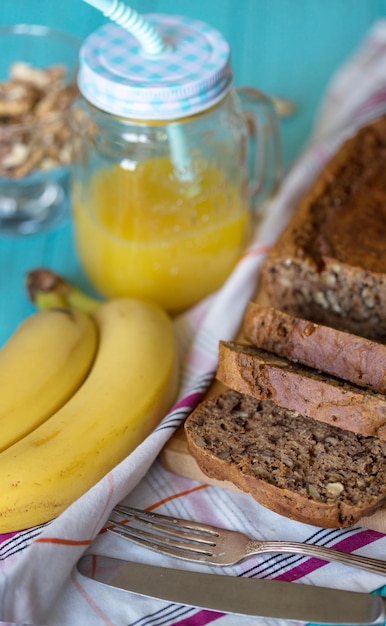 Zdrowe odżywianie. Chleb bananowy, banany i sok pomarańczowy na stole