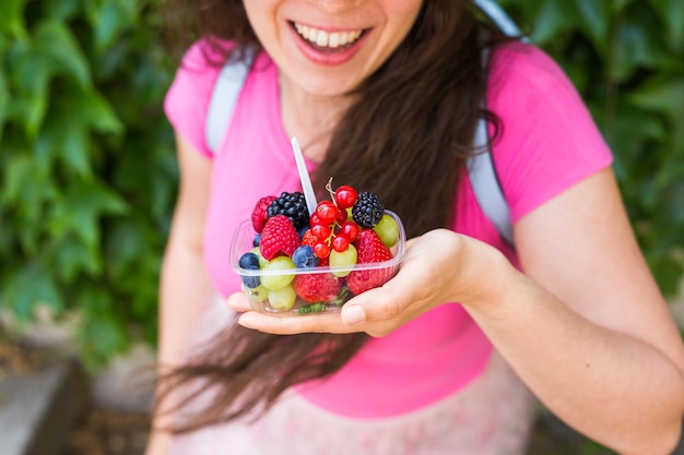Zdrowe odżywianie, diety, wegetariańskie jedzenie i koncepcja ludzie - bliska kobieta ręce trzymając jagody odkryty.