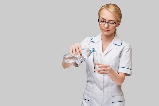 Zdrowe odżywianie lub koncepcja stylu życia - kobieta lekarz trzymając szklankę czystej świeżej wody
