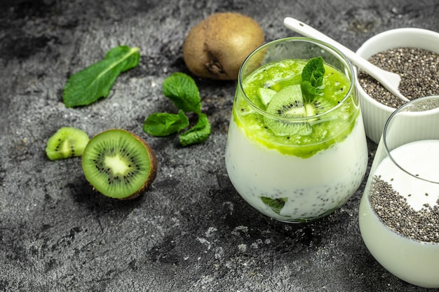 Zdrowe śniadanie budyń chia z kiwi w szklanych słoikach na ciemnym stole czyste jedzenie dieta dieta wegańska koncepcja żywności baner menu przepis miejsce na tekst