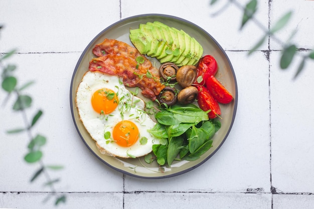 Zdrowe śniadanie keto z jajkiem z awokado i boczkiem wysokiej jakości zdjęcie