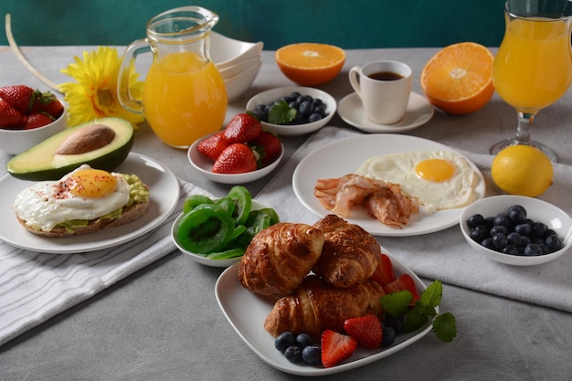 Zdrowe śniadanie Tosty z awokado i bekonem jajecznym oraz jajka ze świeżych i suszonych owoców świeży sok