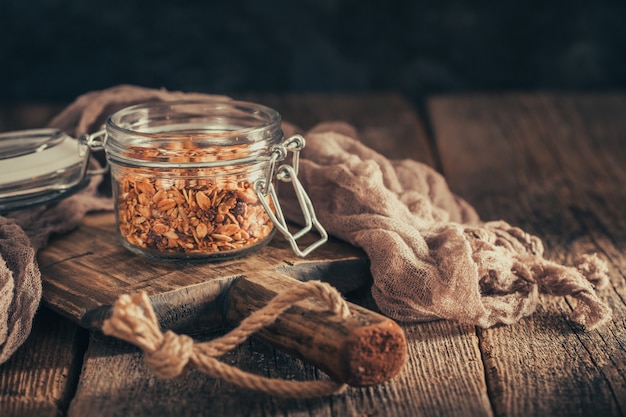 Zdrowe śniadanie z muesli w szklanej misce na ciemnym tle.