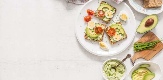 Zdrowe śniadanie Z Tostów Z Awokado Z Pomidorem Jajecznym Guacamole I Szczypiorkiem.