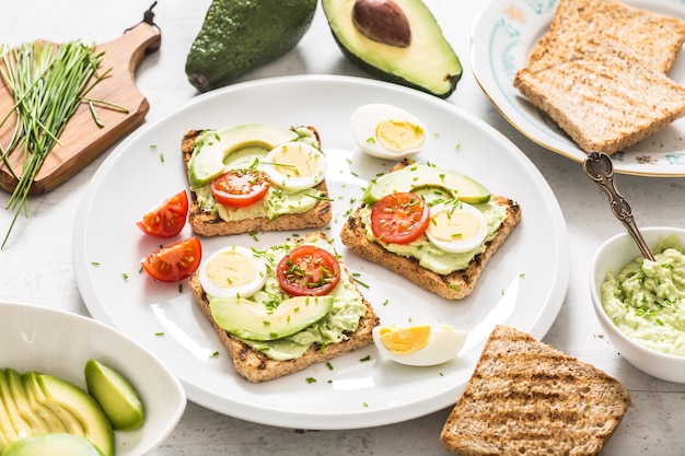 Zdrowe śniadanie Z Tostów Z Awokado Z Pomidorem Jajecznym Guacamole I Szczypiorkiem.