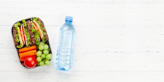 Zdrowe szkolne pudełko na lunch z kanapką i świeżymi warzywami