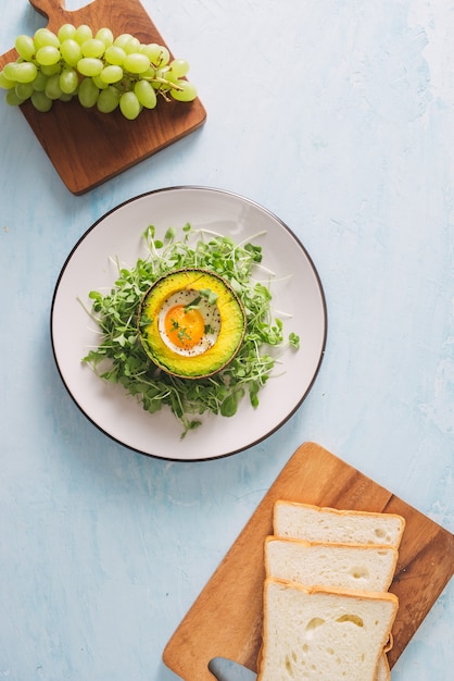 Zdrowe tosty z awokado na śniadanie lub lunch z chlebem, pokrojonym awokado, rukolą, pestkami dyni i sezamu, solą i pieprzem. Kanapki wegetariańskie. Dieta roślinna. Cała koncepcja żywności.