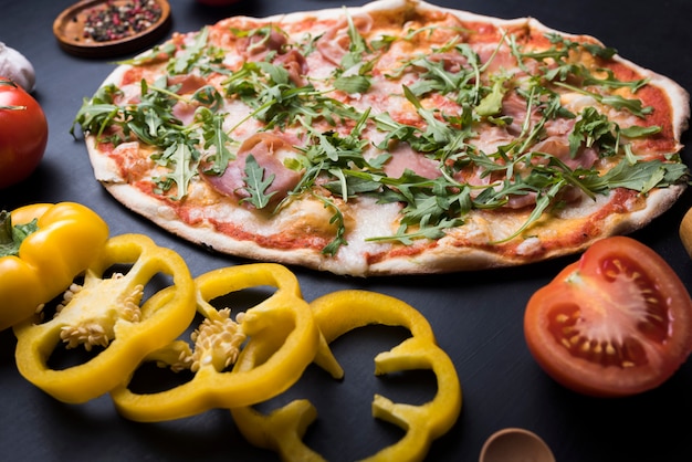 Zdjęcie zdrowe warzywa i pizza arugula nad blatem kuchennym