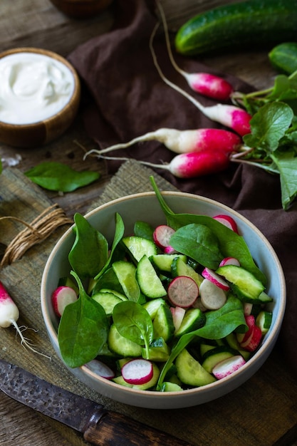 Zdrowe wegańskie jedzenie Wegetariańska sałatka warzywna ze szpinaku, rzodkiewki i świeżego ogórka