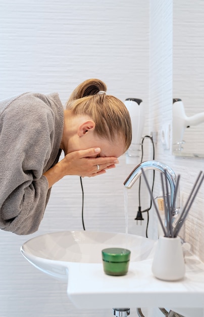 Zdrowie Kobiet. Spa I Wellness. Kobieta Myjąca Twarz W łazience