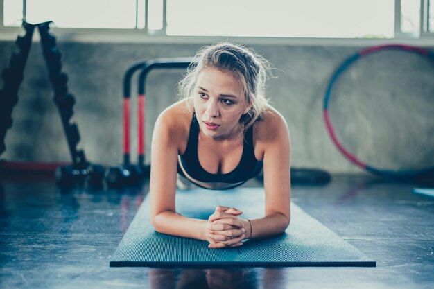 Zdrowie psychiczne i dobre samopoczucie. Dopasowany i jędrny dla zdrowia. Ulepszenia umysłu i ciała. Sportwomen ćwiczących na siłowni.