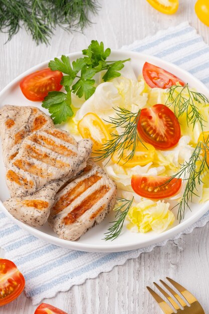Zdrowy ketogeniczny obiad z grillowanym kurczakiem, organicznymi pomidorami i warzywami