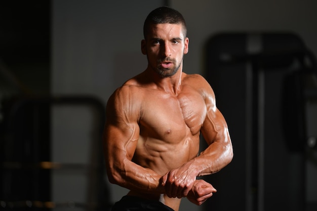 Zdrowy Mężczyzna Stojący Silny Na Siłowni I Napinający Mięśnie Mięśni Atletyczny Kulturysta Model Fitness Pozujący Po ćwiczeniach