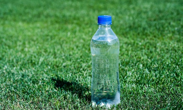 Zdrowy napój ochrona środowiska globalna ochrona środowiska plastikowe śmieci potrzeba recyklingu świeże i czyste uczucie spragniony czyste naturalne picie witamin mineralnych butelka wody na zielonej trawie sport i fitness