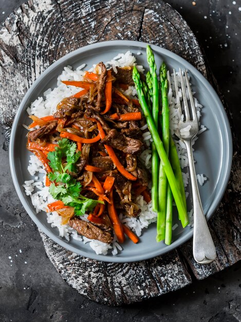 Zdrowy obiad pikantny stir fry szparagi wołowe ryżowe na ciemnym tle widok z góry