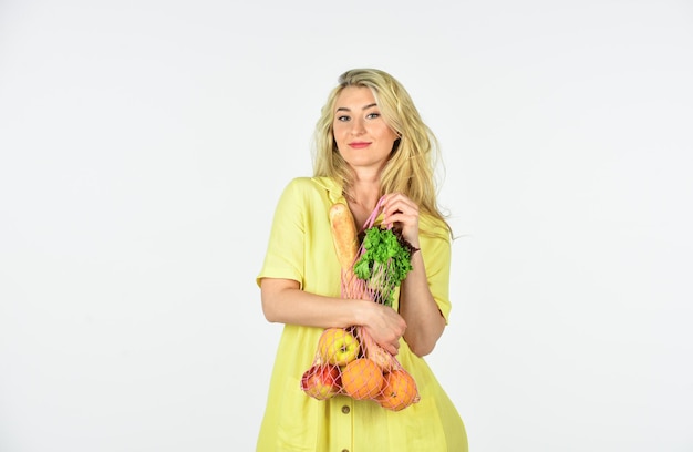 Zdrowy styl życia dbaj o zdrowie sprawność fizyczna i dieta żywność ekologiczna tylko kobieta nosi jabłko pomarańcza sałatka i chleb w torbie sznurkowej dziewczyna idzie na zakupy niesie ładny zakup warzywna dieta