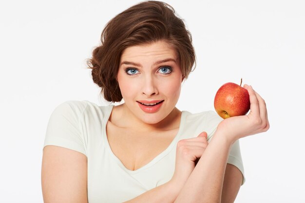 Zdrowy wybór Portret ładnej brunetki trzymającej czerwone jabłko