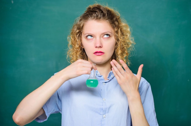 Zdjęcie zdumiewający zapach dziewczyna trzyma butelkę chemiczną z płynną uczennicą ze zlewką chemia wyniki badań biologia eksperyment próbka formuła naukowiec w szkole laboratorium lekcja w szkole naukowiec w pracy