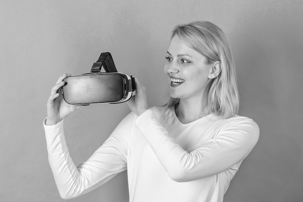 Zdumiona młoda kobieta dotykająca powietrza podczas korzystania z wirtualnej rzeczywistości Młoda kobieta korzystająca z wirtualnej rzeczywistości